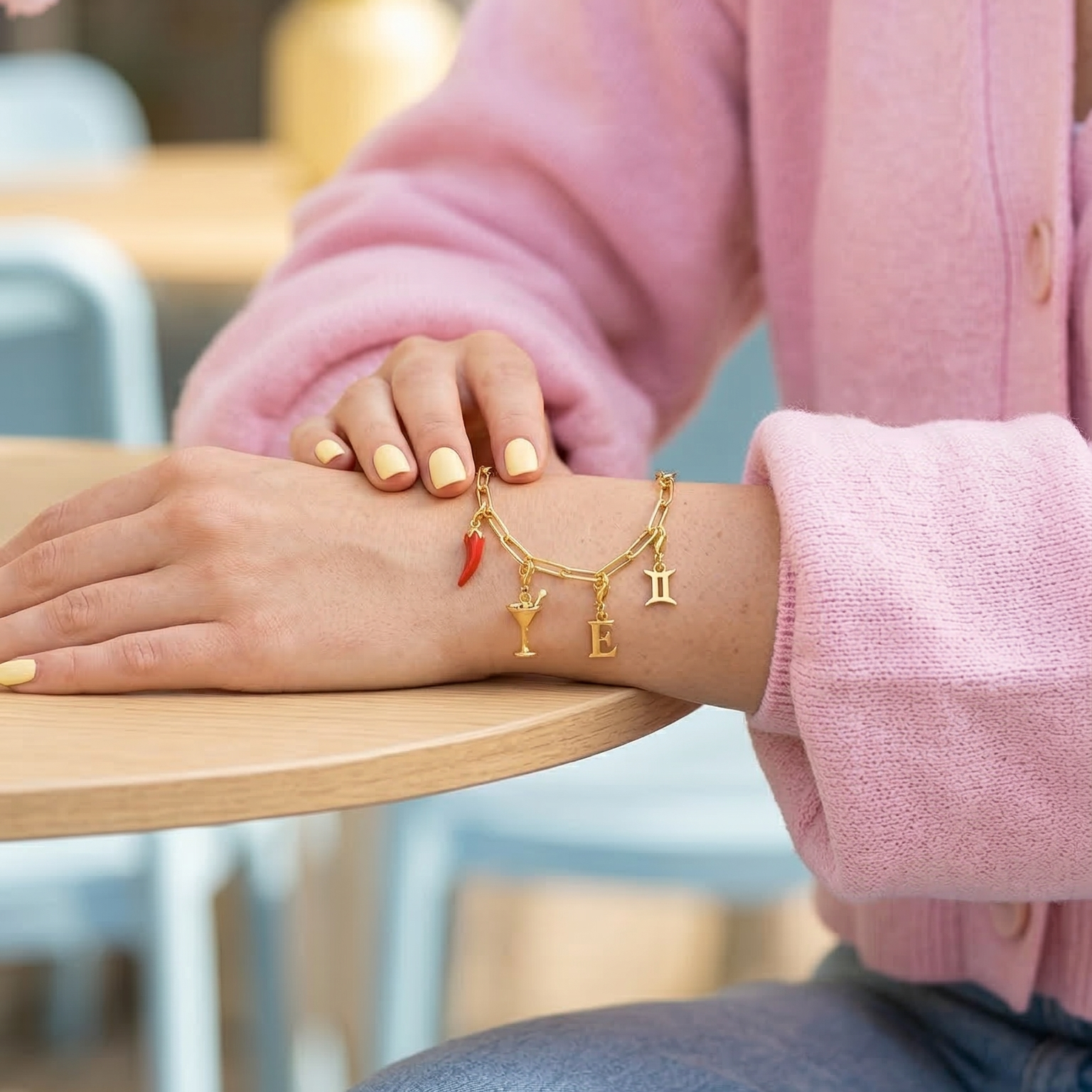Armband mit Charmsüber Arm am Tisch
