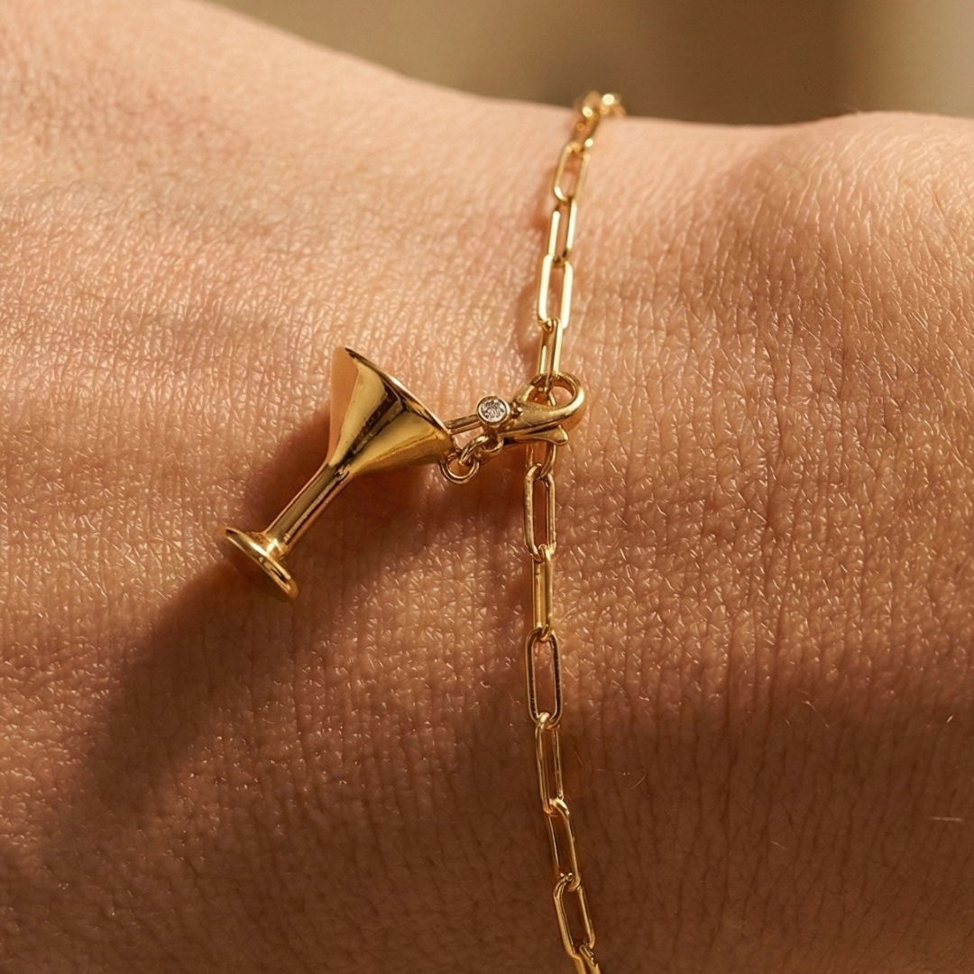 Der Cocktail Charm in gold an einem goldenen Paperclip Armband um ein weibliches Handgelenk