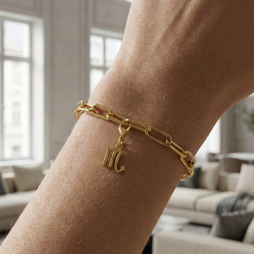 Charm Sternzeichen Skorpion in gold hängt an goldenem Armband am Handgelenk. Im Hintergrund stylische Altbauwohnung