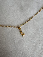 Goldener Steinbock Sternzeichen Charm an  goldenem Armband liegt auf weißem Leinentuch